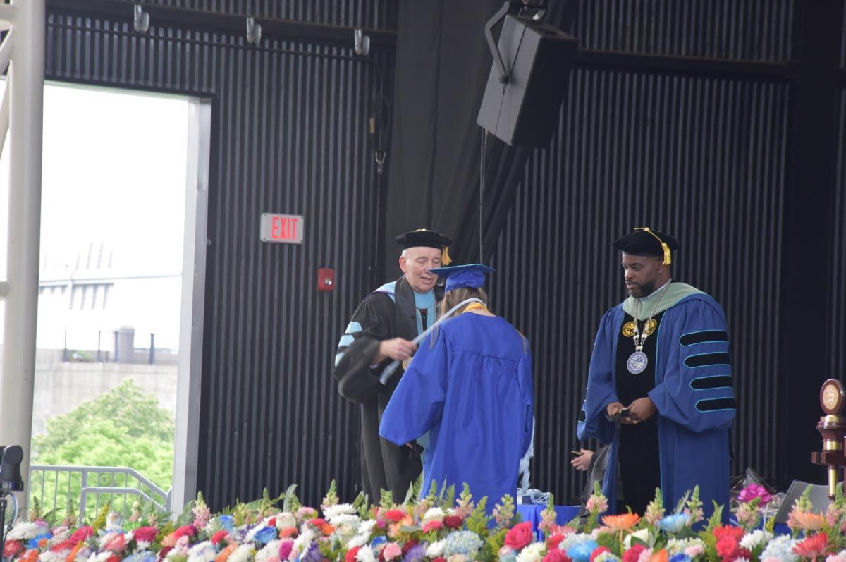 Dr. Kalicki and Dr. Maduko greeting student on stage