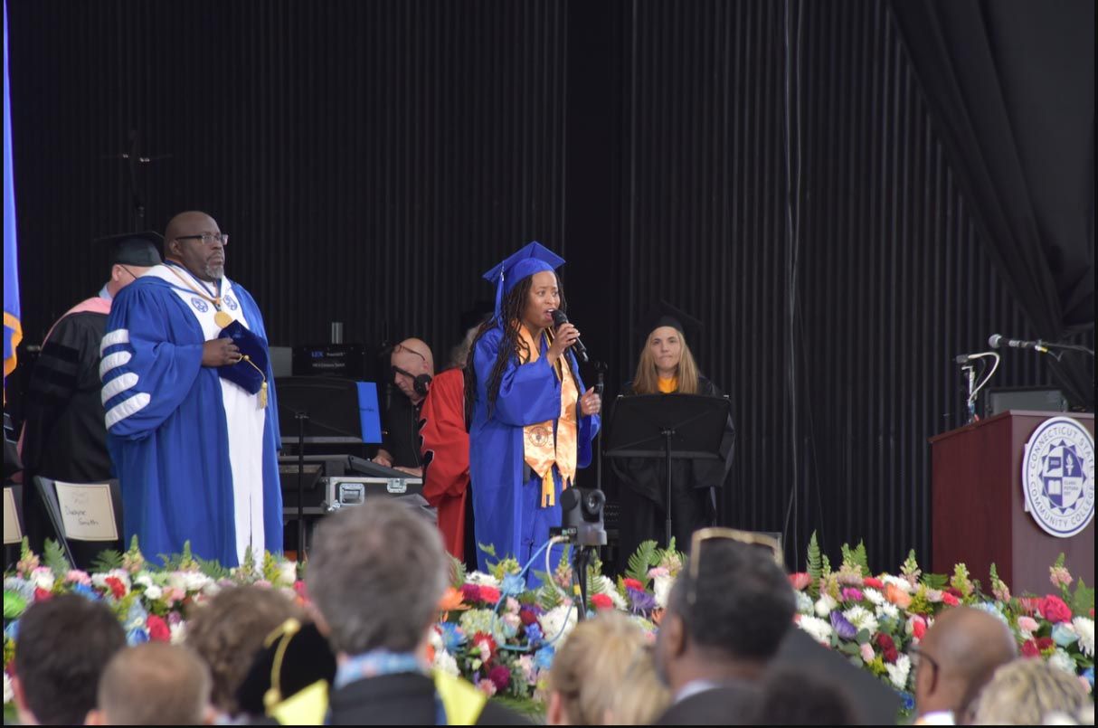 A signer on stage during commencement ceremony